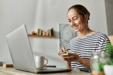 Young woman with vitiligo smiles while crafting at her home workspace. clipart