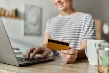 Vitiligo 'su olan bir kadın bir kafede dizüstü bilgisayarıyla çalışırken gülümsüyor..