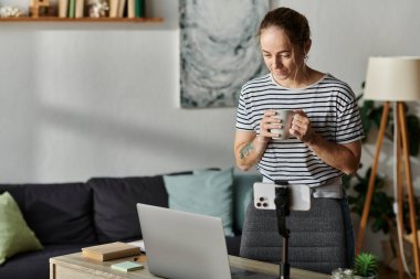 Vitiligo 'su olan bir kadın sıcak bir içecek tutarken nazikçe gülümser..