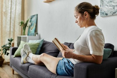 A woman enjoys a quiet moment immersed in her book on a sunny afternoon. clipart