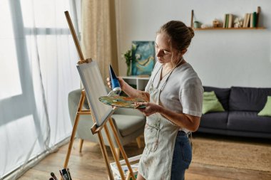 Yetenekli bir kadın güneşli, rahat bir stüdyoda sanat yaratıyor..