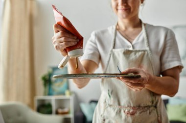 Vitiligo 'su olan güzel bir kadın canlı bir sanat alanında boya karıştırıyor..