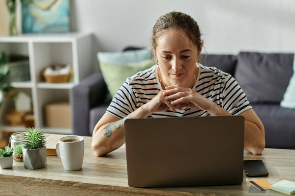A woman with vitiligo sits thoughtfully at her desk, immersed in her online world.