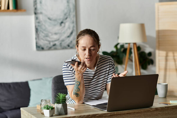 Young woman with vitiligo actively speaks on smartphone in cozy workspace.