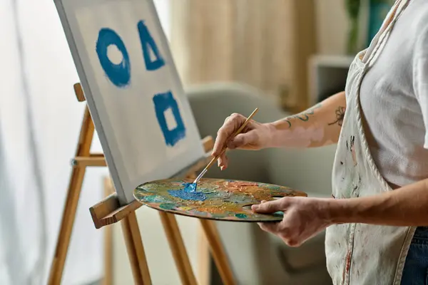 stock image A woman with vitiligo creates vibrant shapes on canvas.