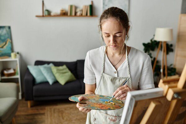 Красивая женщина выражает свое творчество яркими красками в теплом пространстве.