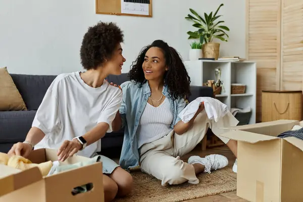 Stock image Two partners joyfully transform old clothes into new styles at home.