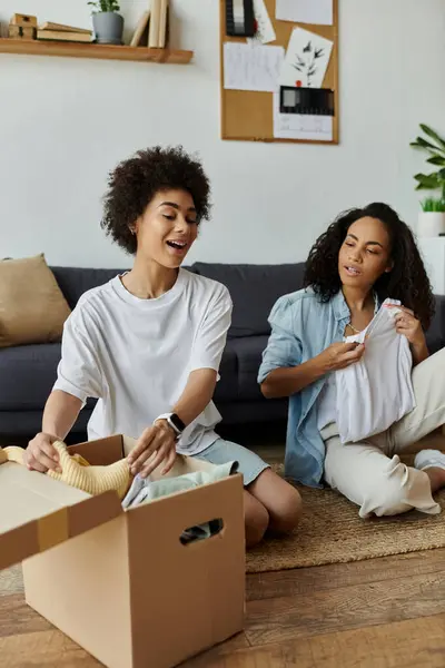 Stock image A joyful couple transforms old clothes into new creations in their living room.