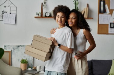 Yaratıcı giysilerle mutlu mesut ilgilenen çift evde bisiklet sürüyor, kutu ellerinde..