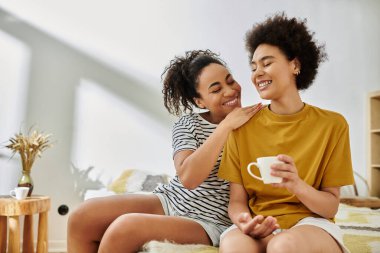 İki kadın sıcak bir atmosferde kahvelerini yudumlarken aynı neşeyi ve kahkahayı paylaşıyor..