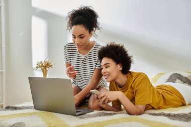 Sevgi dolu bir çift dizüstü bilgisayar kullanırken gülüşlerini ve bağlantılarını paylaşıyor.