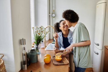 A couple enjoys cooking together in their warm, inviting kitchen. clipart