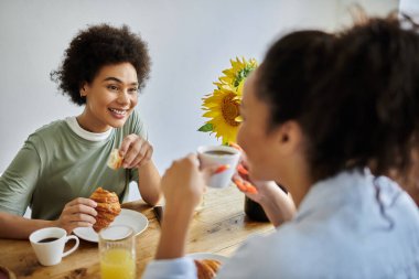 Sevgi dolu bir çift brunch 'tan zevk alır, gülümser ve hamur işlerini paylaşır..