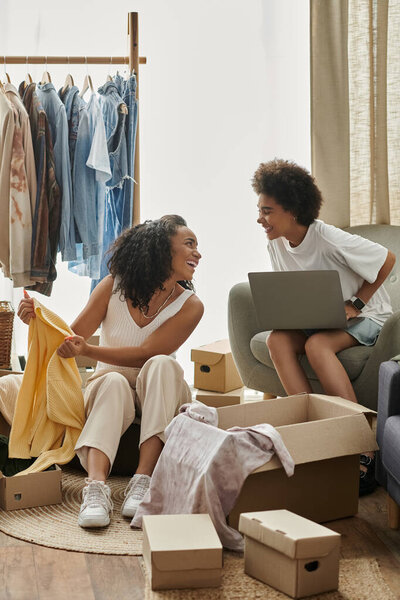 Пара радостно обновляет свой гардероб в окружении веселых тканей и коробок.