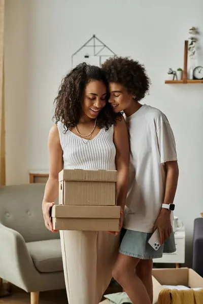 stock image A couple lovingly transforms their old clothes into new creations, box in hands.