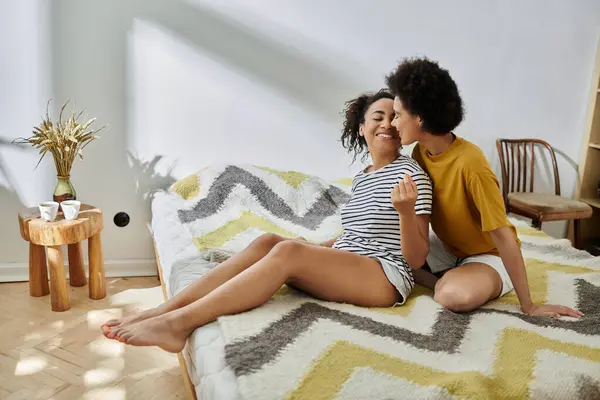 stock image Couple shares tender moments on their chic bed with vibrant decor.