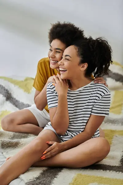 stock image Two women share laughter while relaxing together in their cozy space.