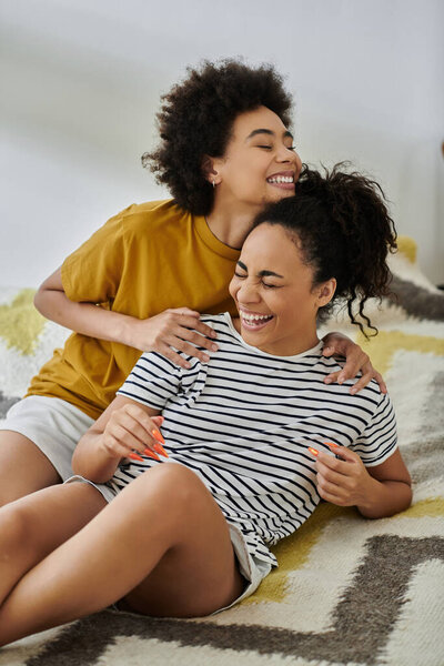 A loving couple shares laughter while relaxing together on the floor.