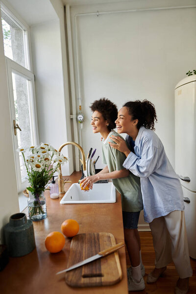 A couple shares laughter while preparing breakfast together at home.