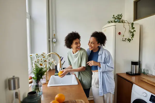 stock image A loving couple shares laughter while preparing fresh fruit in their cozy kitchen.