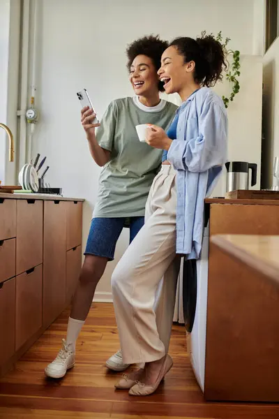 stock image A loving couple shares laughter while engaging with a phone.