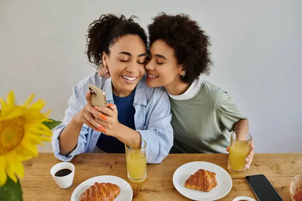 stock image A happy couple shares laughter and drinks at their cozy breakfast table.