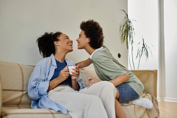 A loving couple shares laughter and warmth while relaxing on their cozy couch.