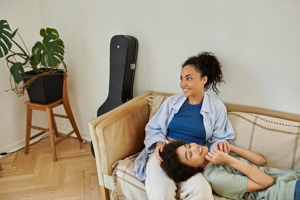 Two partners share a joyful moment in their cozy living space.