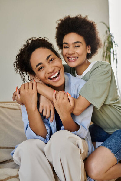 A cheerful couple shares a loving embrace while relaxing indoors.