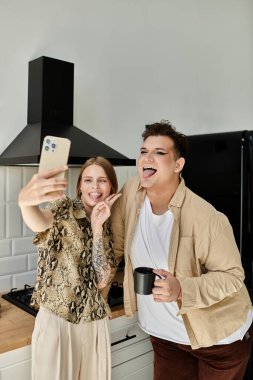 İki arkadaş, evde kahkahalarını paylaşırken neşeli bir selfie çekiyorlar..