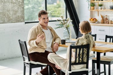 İki arkadaş, sıcak bir evde kahve eşliğinde keyifli bir anı paylaşıyor..