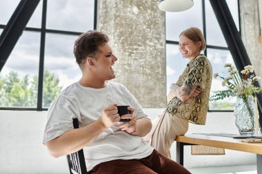 İki arkadaş, modern bir evde kahve içerken keyifli anlar yaşıyor..