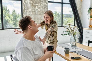 İki arkadaş, modern ve rahat bir yaşam alanında aynı kahkahayı paylaşıyor..