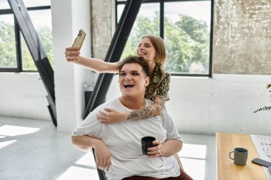 Sıcak bir ortamda selfie çekerken iki arkadaş gülüşür..