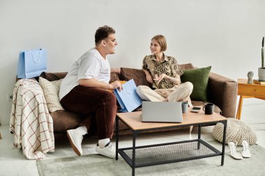 İki arkadaş şık bir oturma odasında kahkaha ve sohbeti paylaşıyor..