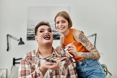 İki arkadaş sıcak bir evde keyifli bir makyaj anını paylaşıyor..