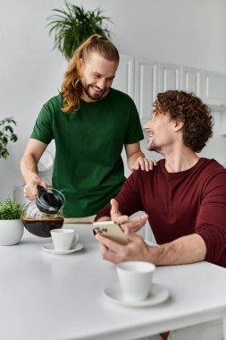 A couple shares joyful moments while enjoying coffee at home. clipart