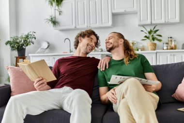 A happy couple enjoys quality time together on their cozy couch. clipart