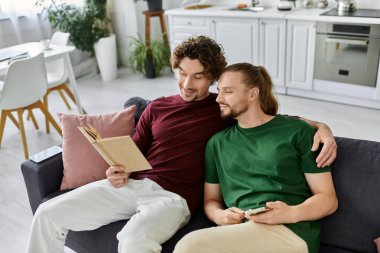 İki ortak, parlak oturma odalarındaki kanepede kitap okurken rahat bir anı paylaşıyor..