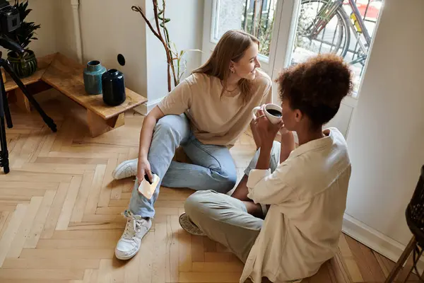 stock image A happy couple shares a warm drink and laughter in their inviting living space.