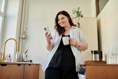 Evde parlak bir sabah, iri yarı bir kadınla kahve içip telefonunu kontrol ediyor..