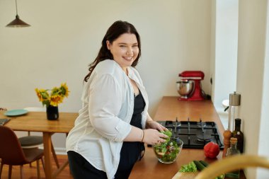 Ayrıca boylu kadın güneşli mutfağında sağlıklı salata yapmayı seviyor..