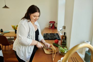 A woman skillfully slices vegetables while enjoying her time in the kitchen. clipart