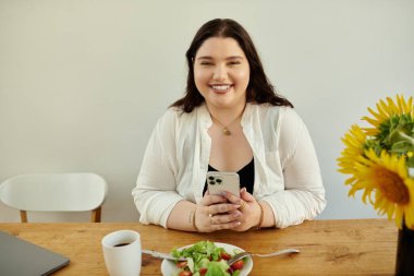 Gülümseyen kadın yemek yerken ve telefonda sohbet ederken rahatlıyor..