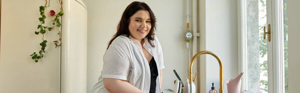 Женщина plus size любит готовить дома на своей веселой кухне.