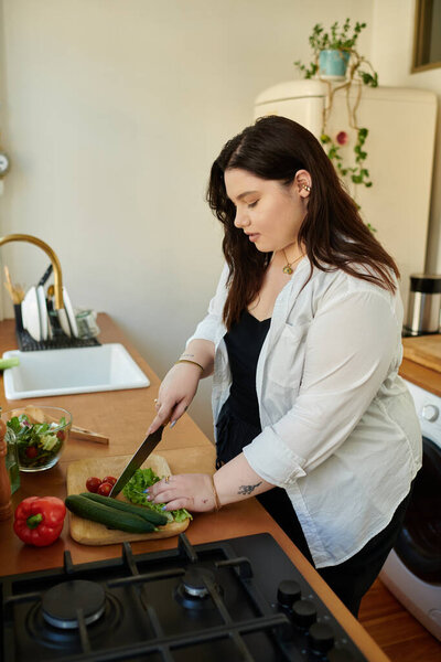 A plus size woman skillfully chops vegetables in her inviting kitchen.