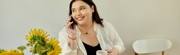 Расслабляясь дома, счастливая женщина держит кофе во время разговора по телефону.