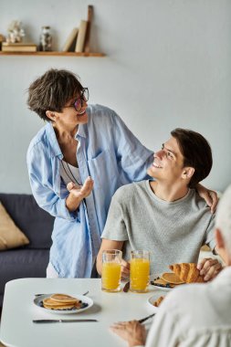 Sevgi dolu bir LGBTQ ailesi ile sıcak bir sabah kahvaltısı gülümsemeleri ve leziz krepleri paylaşıyor..