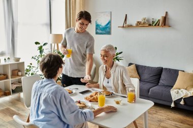 Lezbiyen ebeveynler ve yetişkin oğullarıyla sıcak bir sabah kahvaltısı ve kahkahası..