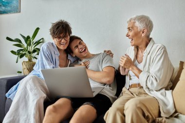 A loving LGBTQ family shares laughter and joy while watching something together at home. clipart